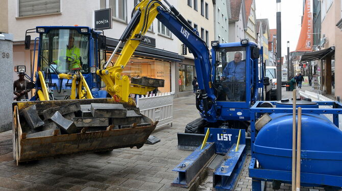 Mit speziellen Gerätschaften werden die schweren Rinnen-Betonsteine in der unteren Wilhelmstraße vom Fundament gehoben und durch
