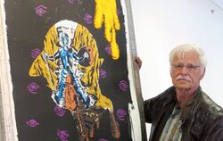 Kurator Rudolf Greiner mit einer Druckgrafik Immendorffs, in der er Don Quijote in der Silhouette des eigenen Kopfes platziert.