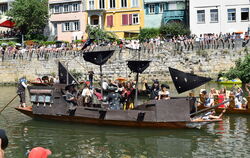 Ein imposant zum Piratenschiff aufgerüsteter Kahn (rechts) zieht beim Kostümwettbewerb des Stocherkahnrennens in Tübingen die Bl