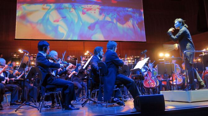 Debussys Orchesterklänge treffen auf die Projektionen von Casa Magica. Rechts Dirigentin Shiyeon Sung.  FOTO: KNAUER