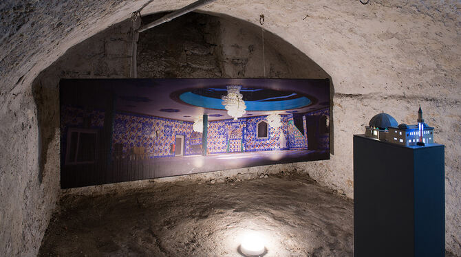 Peter Schmidt zeigt im Keller unter dem Pfarrhaus seine zweigeteilte Arbeit: »Dantes Göttliche Komödie und die Moschee«.  FOTO: