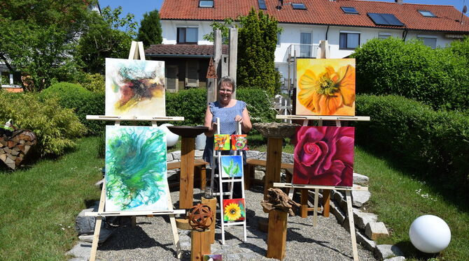 Evelyn Hay mit einer Auswahl ihrer Werke im heimischen Garten in Eningen. FOTO: HAILFINGER