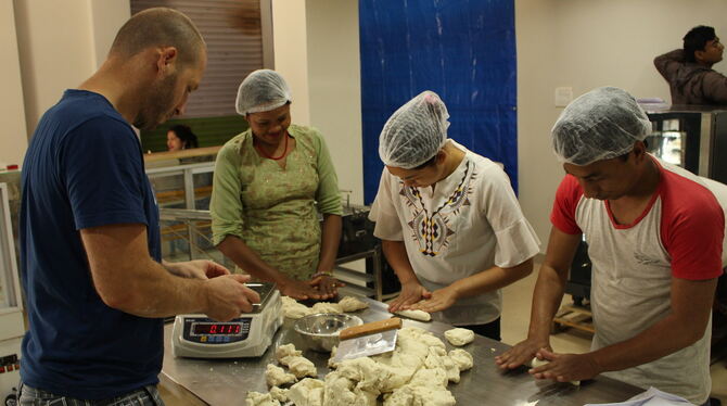 Bäckermeister Michael Moll bereitet mit seinen nepalesischen Helfern den Backteig für seine Brezeln vor.