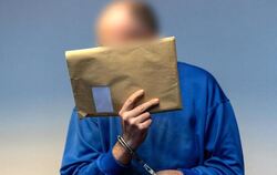 Ein Mann hält sich einen Briefumschlag vors Gesicht