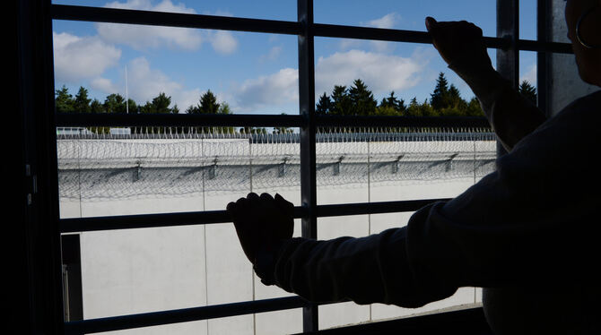 Ein Häftling schaut aus seinem vergitterten Fenster auf Gefägnismauern. Drogen finden immer wieder einen Weg darüber.  FOTO: DPA