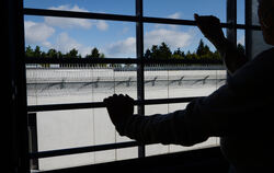 Ein Häftling schaut aus seinem vergitterten Fenster auf Gefägnismauern. Drogen finden immer wieder einen Weg darüber.  FOTO: DPA