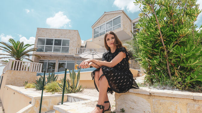 Fernsehmoderatorin Cathy Hummels sitzt vor ihrer Luxusvilla CaMa.