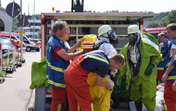 Fertig machen für den Ernstfall: Feuerwehrleute mit Schutzanzügen und Atemmasken untersuchten die schadhaften Gasflaschen vor de