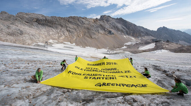 Greenpeace-Aktivisten spannen auf der Zugspitze ein Transparent auf.  FOTOS: DPA UND BERND LAUTER/GREENPEACE