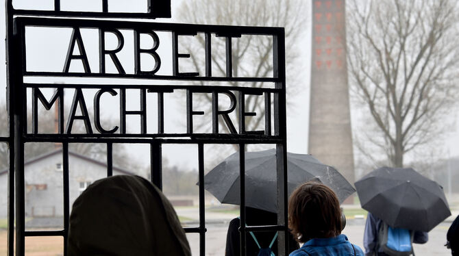 Eine Besuchergruppe geht durch das Tor des früheren Konzentrationslagers Sachsenhausen mit der Aufschrift »Arbeit macht frei«. (