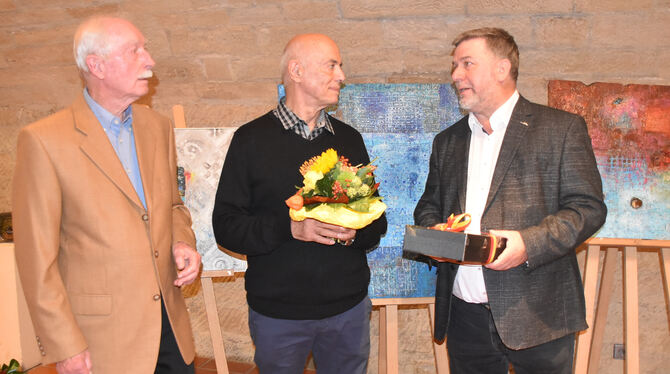 Der irakische Künstler Kamal H. Yousif wird bei der Vernissage von Laudator Gerhard Egbers und Bürgermeister Michael Hillert (re
