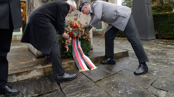 Bürgermeister Robert Hahn und Jörg Hildenbrand von der Reservistenkameradschaft Reutlingen legen einen Kranz nieder. FOTO: PIETH