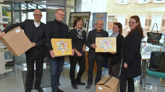 Mitglieder des Lions-Clubs Reutlingen übergeben die frei verkäuflichen Exemplare des Lions-Adventskalenders 2018 an Mitarbeiteri