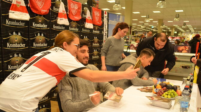Berkay Özcan (links) und Erik Thommy (rechts am Tisch) beglücken bei der Autogrammstunde eine lange Schlange von Fans.