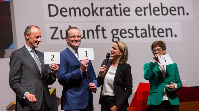 Friedrich Merz (links), Jens Spahn und Annegret Kramp-Karrenbauer (rechts) mit den Karten, die zeigen, in welcher Reihenfolge si