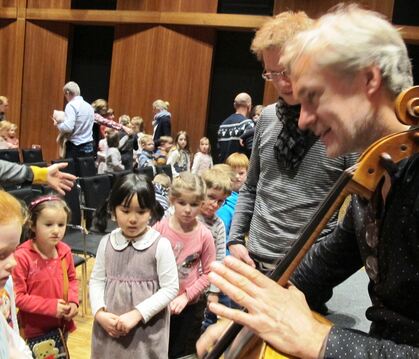 Der Cellist Erik Borgir erklärt Kindern nach der Konzertlesung »Sternenstaub« sein Instrument.  FOTO: CANTRÉ