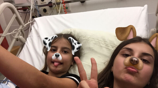 Sinem (rechts) muntert ihre kleine Schwester Simay im Krankenbett auf. FOTO: ZMS