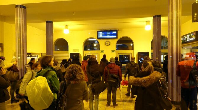 Reisende blicken am Montagmorgen im Hauptbahnhof Reutlingen auf die Anzeigetafel mit der Botschaft: "Beeinträchtigungen im Bahnv