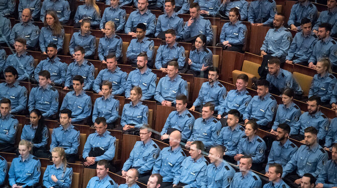 Sie haben es geschafft: Junge Polizeibeamte sitzen bei der feierlichen Vereidigung.  FOTO: DPA
