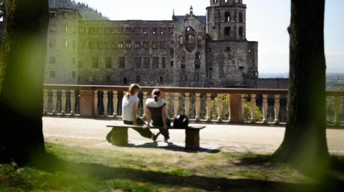 Zwei Frauen sitzen vor dem Heidelberger Schloss