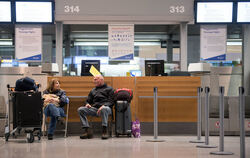Weil das Sicherheitspersonal am Flughafen Stuttgart streikt (oben), warten Passagiere auf einen Bus, der sie zu ihrem Ersatzflug