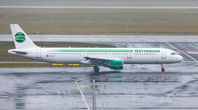 Eine Maschine der Fluggesellschaft Germania rollt bei Regen über das Vorfeld des Düsseldorfer Flughafens.