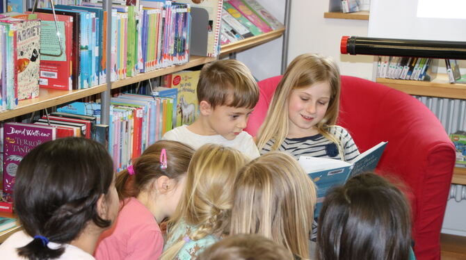 Die Drittklässler Ben Höss und Pauline Löffler lesen im Rahmen der Lesestrolche-Reihe jüngeren Kindern vor.  FOTO: OECHSNER