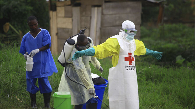Ebola ist höchst ansteckend. Hier wird ein Helfer nach einem Einsatz im Kongo mit Desinfektionsmittel eingesprüht. FOTO: DPA