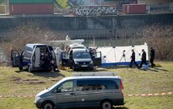Polizisten sichern am Neckarufer die Fundstelle einer Leiche