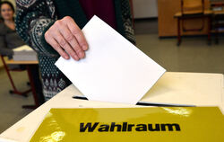 Eine Frau steckt in einem Wahllokal ihren Stimmzettel in eine Wahlurne. FOTO: DPA