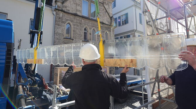 Vorsichtig hieven Mitarbeiter der Augsburger Firma Seele mithilfe eines Krans den ersten Glasziegelbalken in Richtung Musterfass