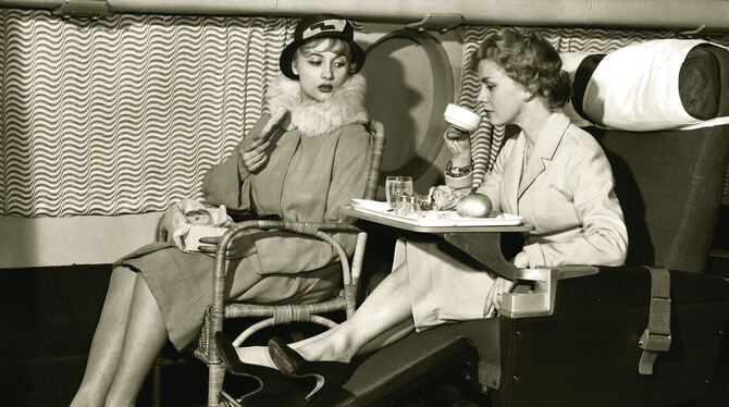 Sitzvergleich 1957: Janice van Ayre (links) hat auf einem Flugzeugsitz von 1928 Platz genommen, auf dem Schoß eine Schachtel mit