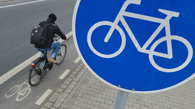 Ein Mann fährt mit seinem Fahrrad auf einem mit einem Verkehrsschild gekennzeichneten Radweg. FOTO: DPA