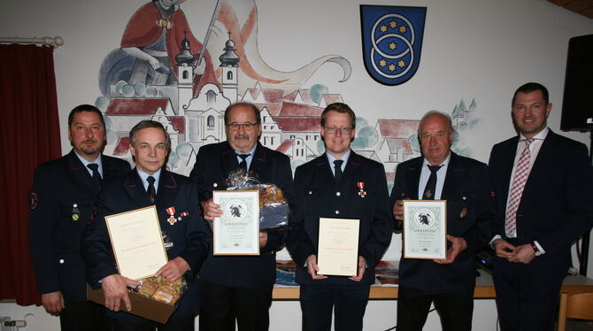 Bürgermeister  Matthias Henne (rechts) ehrte langjährige Feuerwehrmänner.  FOTO: THUMM