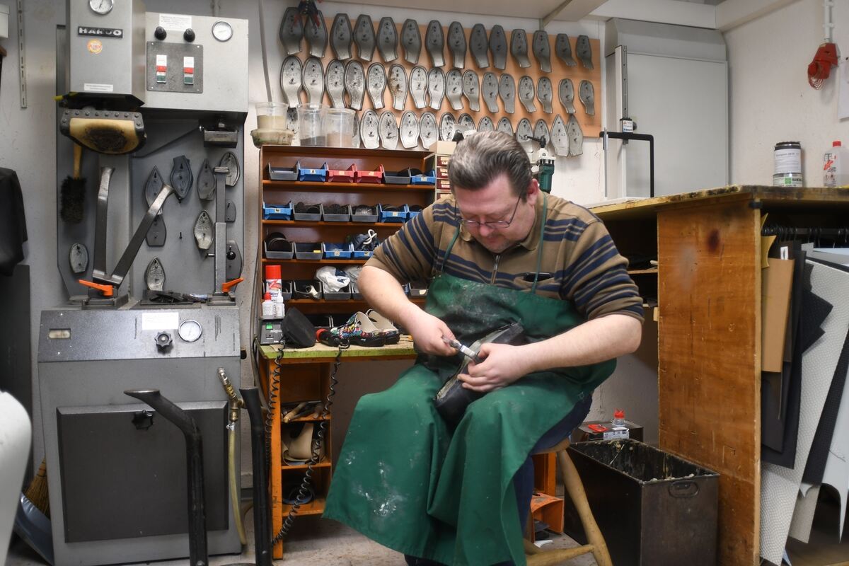 Viktor Schneider sitzt bei der Arbeit in seiner Werkstatt.