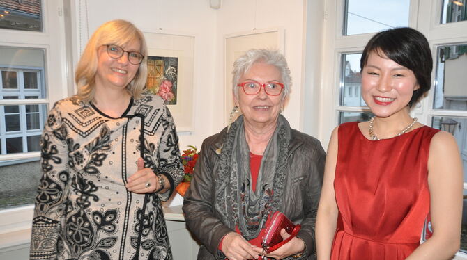 Vernissage in Eningen mit (von links) Andrea Bachmann, Künstlerin Marlene Neumann und Sängerin Karera Fujita.  FOTO: BIMEK
