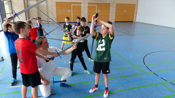 Trainer Wolfgang Abart zeigt den Jungs, wie sie das Schwert richtig halten. FOTO: WEBER