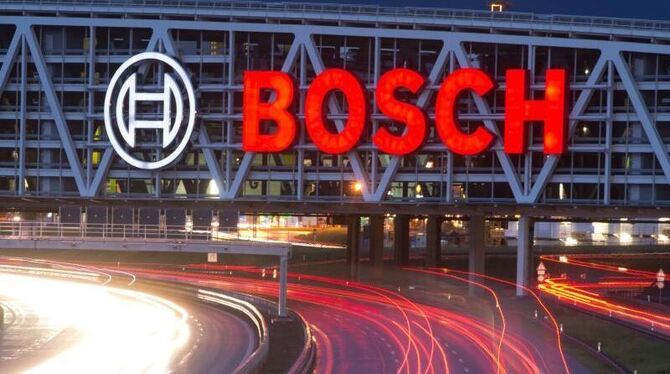 Autos fahren unter einer Brücke mit dem Bosch-Logo entlang