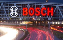 Autos fahren unter einer Brücke mit dem Bosch-Logo entlang