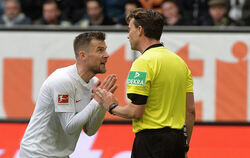 Ich doch nicht! Augsburgs Daniel Baier und Schiedsrichter Guido Winkmann.  FOTO: DPA