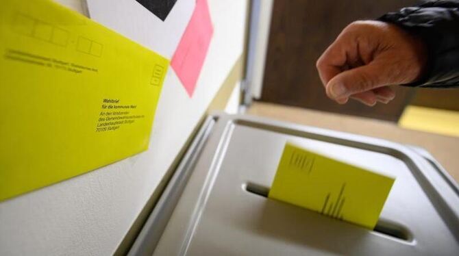 Ein Mann wirft einen Wahlbrief in eine Wahlurne