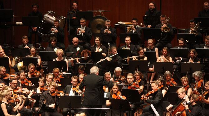 Rainer M. Schmid dirigierte beim Festkonzert in der Stadthalle die um Ehemalige erweiterte Junge Sinfonie.  FOTO: STRÖHLE