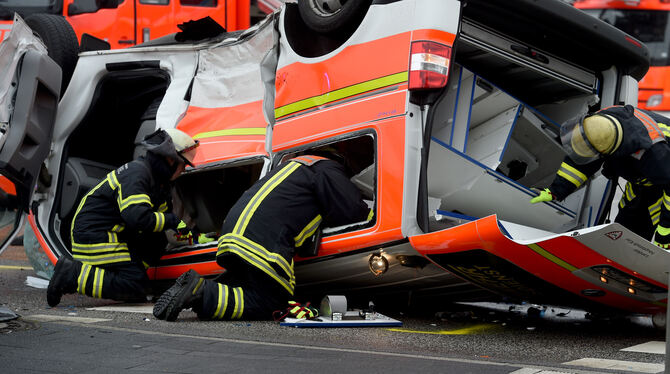 Ein zerstörtes Notarzteinsatzfahrzeug liegt auf dem Dach. Der Rettungswagen war auf einer Einsatzfahrt mit einem Personenwagen z