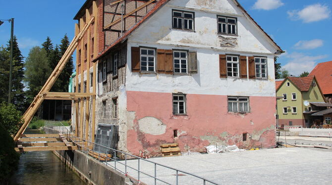 Während der Bauarbeiten an Dach und Westgiebel wird die Gomadinger Mühle sicherheitshalber abgestützt. FOTO: DEWALD