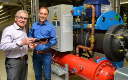 Energieexperten von Bosch in Reutlingen: Helmut Lepple (links) und Mario Kauderer vor einer Wärmepumpe. FOTO: NIETHAMMER