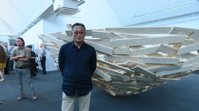 Das Lächeln ist ihm nicht vergangen durch das Scheitern seiner Außenarbeit: Tadashi Kawamata vor seiner Installation "Nest on th