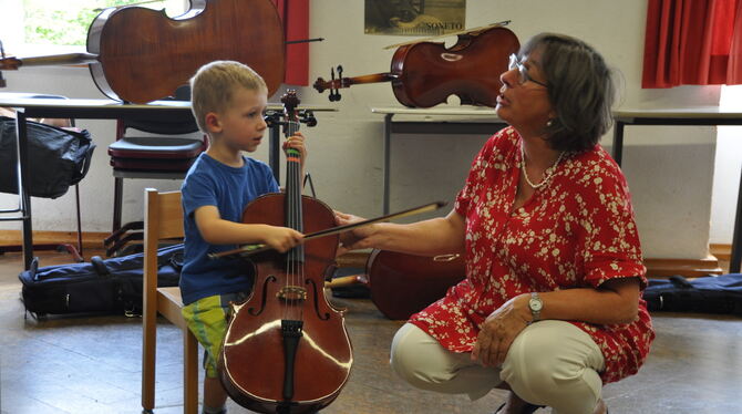 Der dreijährige Felix will Cello spielen. Lehrerin Stephanie Bellmann hilft bei den ersten Versuchen.  FOTO: MEK