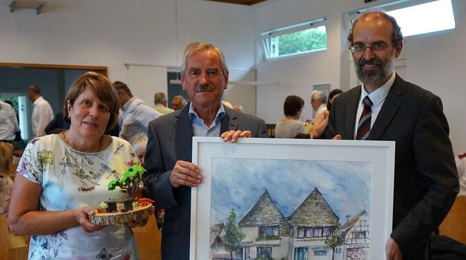 Marlene und Friedrich Braun erhalten von Bürgermeister Jürgen Soltau ein Bild des Rathauses, gemalt von der Reutlinger Künstleri