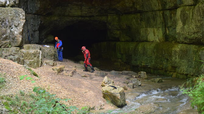 Zwei Höhlenretter vor dem mächtigen Portal der Falkensteiner Höhle unterhalb von Grabenstetten, in der ein Höhlenführer und sein
