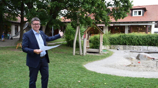 Bürgermeister  Siegmund Ganser im Garten des  Kindergartens von Hülben. Dort, wo das Gebäude und die Spielgeräte zu sehen sind,